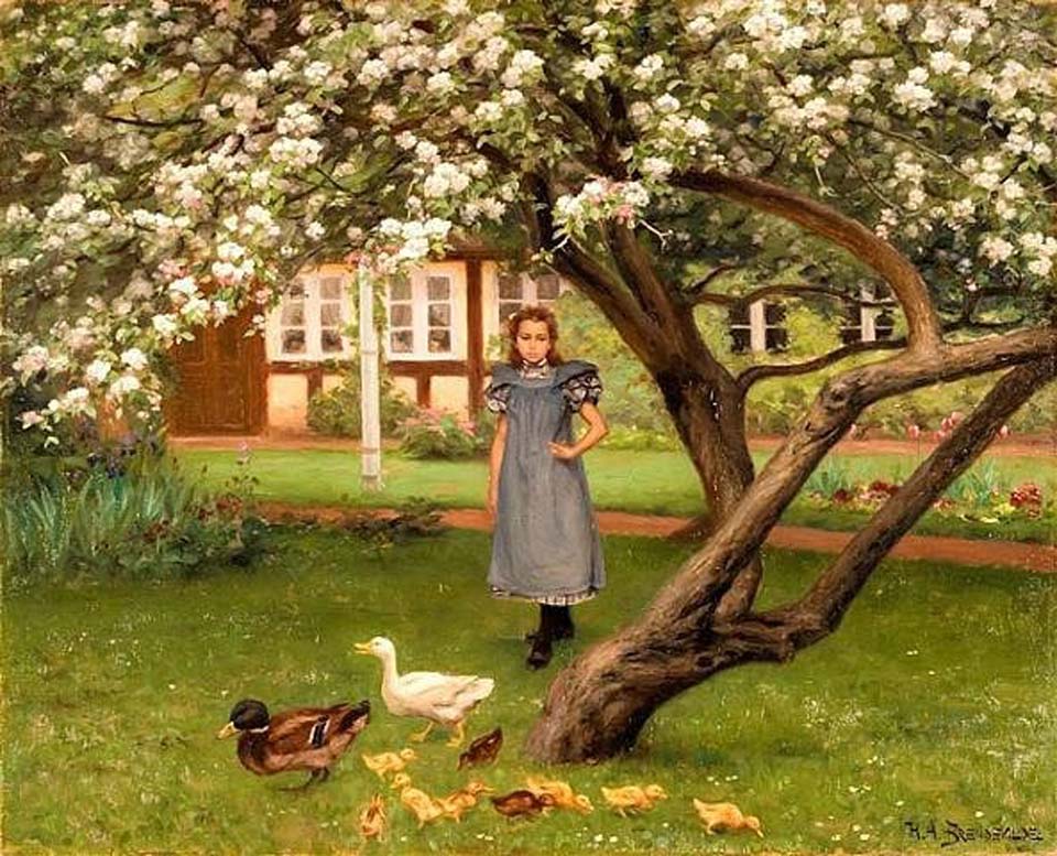 A young girl standing under an apple tree in bloom
